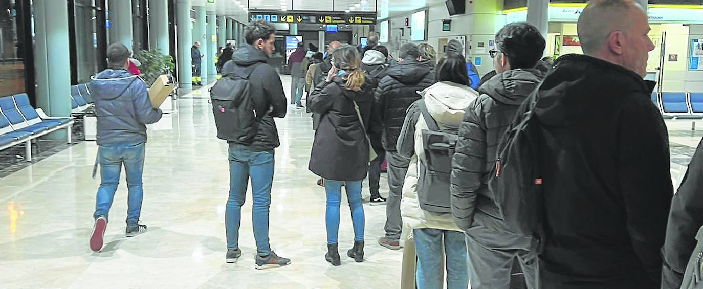 Las colas para el acceso a las puertas de embarque llegan hasta la zona de mostradores, a la entrada del aeropuerto.