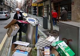 La cocinera de un restaurante pulpería de la calle Aquilino Hurlé de Gijón deposita cartón junto al contenedor.