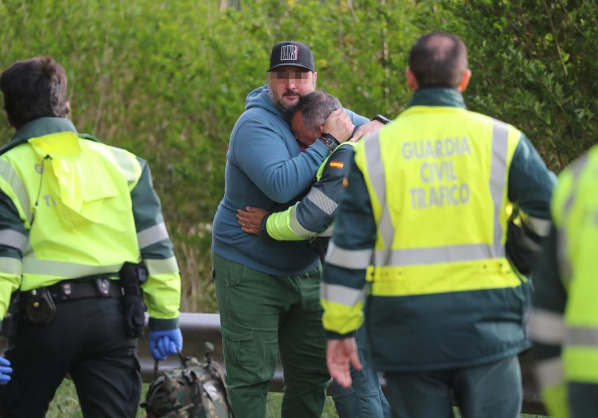 Un vecino de la zona consuela a uno de los guardias civiles, roto por el dolor en el lugar del accidente.