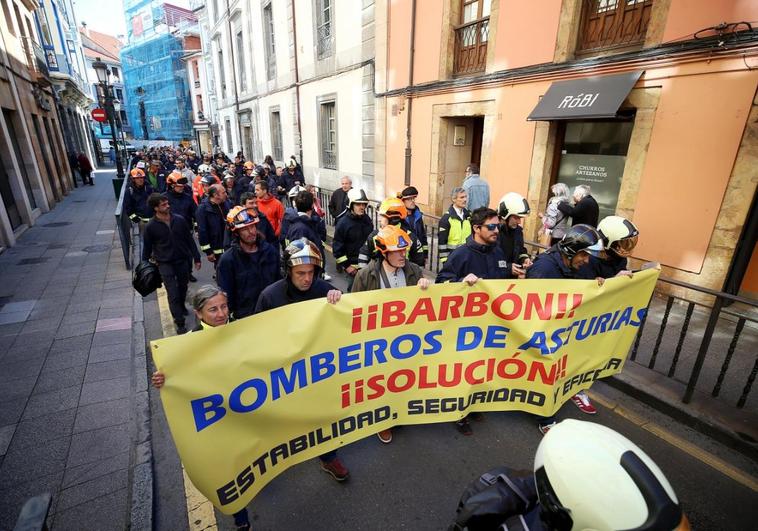 Un centenar de bomberos, con pancartas y uniformes, marcharon en Oviedo para reivindicar la mejora de sus condiciones laborales.