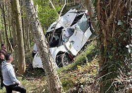 Tres personas observan el coche de Castrillo y Álvarez en el lugar del accidente, el pasado sábado.