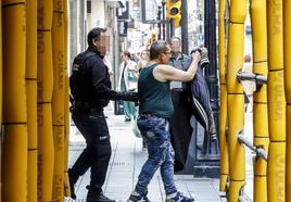 Un agente de policía, con el arrestado.