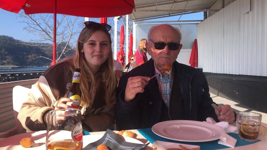 Claudia con su abuelo en una comida familiar.