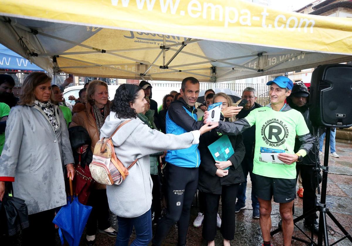 Pilar López le entrega a Nico el dorsal 0 que portó el sobrino del fallecido Rober, Roberto González, de 14 años, que corrió hasta Grado.