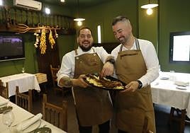 Francisco González y Hugo Rojo, con el plato de paletilla de lechazo.