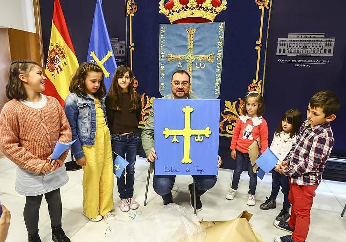 Varios alumnos del Colegio Público Regino Menéndez Antuña posan junto a Adrián Barbón con un lienzo de la bandera de Asturias