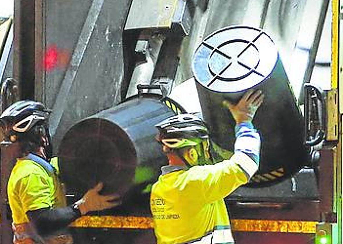 Unos operarios recogiendo basura.