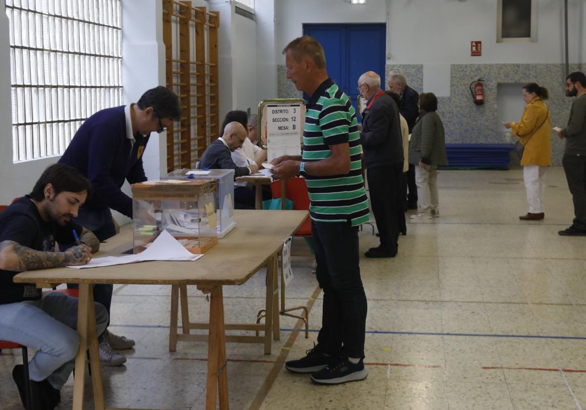 Un gijonés votando en una mesa en el colegio Los Campos.