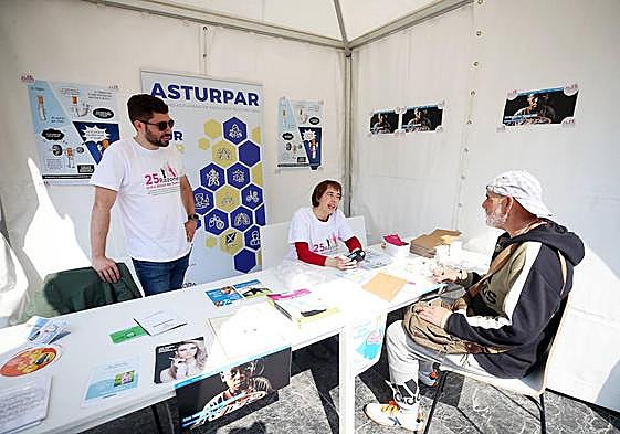 Juan Diego Álvarez y Susana Calvo atienden a un ciudadano en la carpa contra el tabaco.