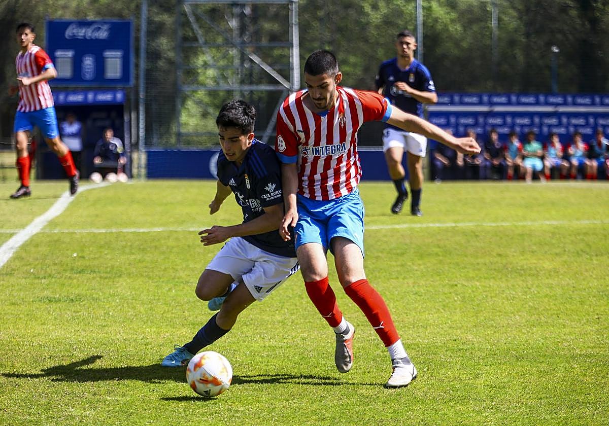 Un juvenil del Sporting pugna por un balón en el derbi.