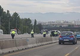 Operarios entre el intenso tráfico de la autovía A-66.