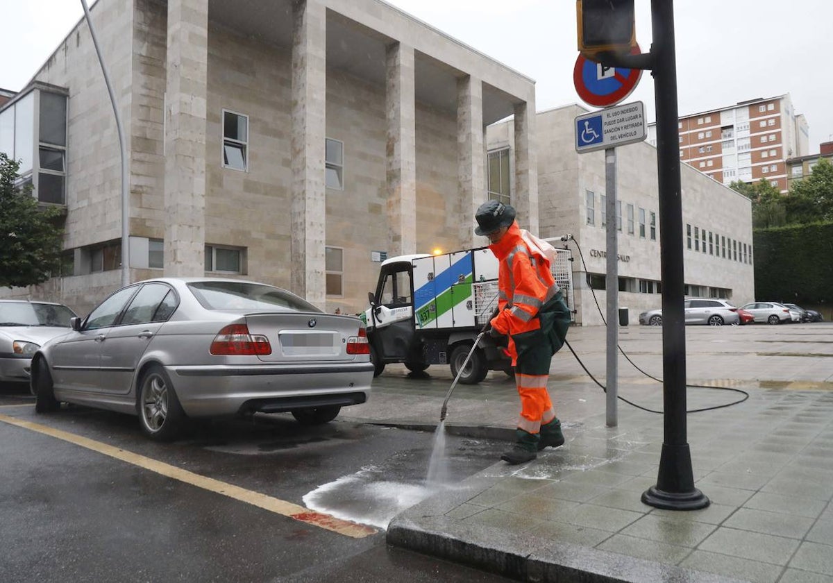 Una trabajadora de Emulsa limpia la sangre en la calle Río de Oro, tras el atropello.