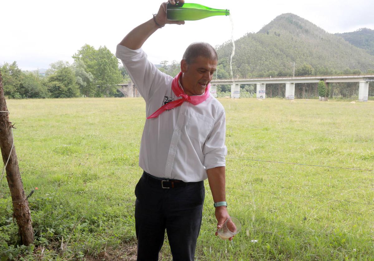 Adolfo Marcos escancia un culín en el prau Salcéu.