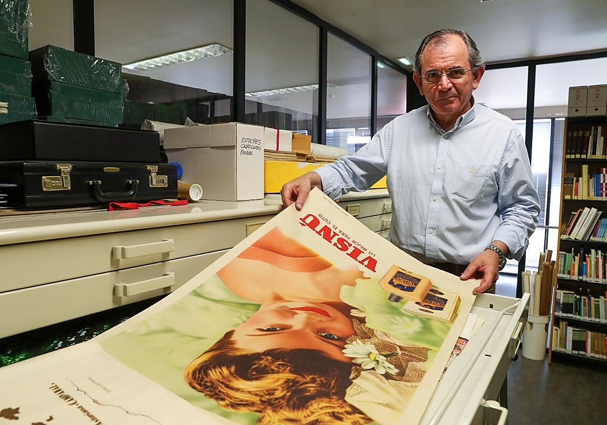 Eduardo Núñez, en una de sus últimas jornadas laborales, sostiene un cartel publicitario de mediados del siglo pasado que forma parte de los fondos del Archivo Municipal.
