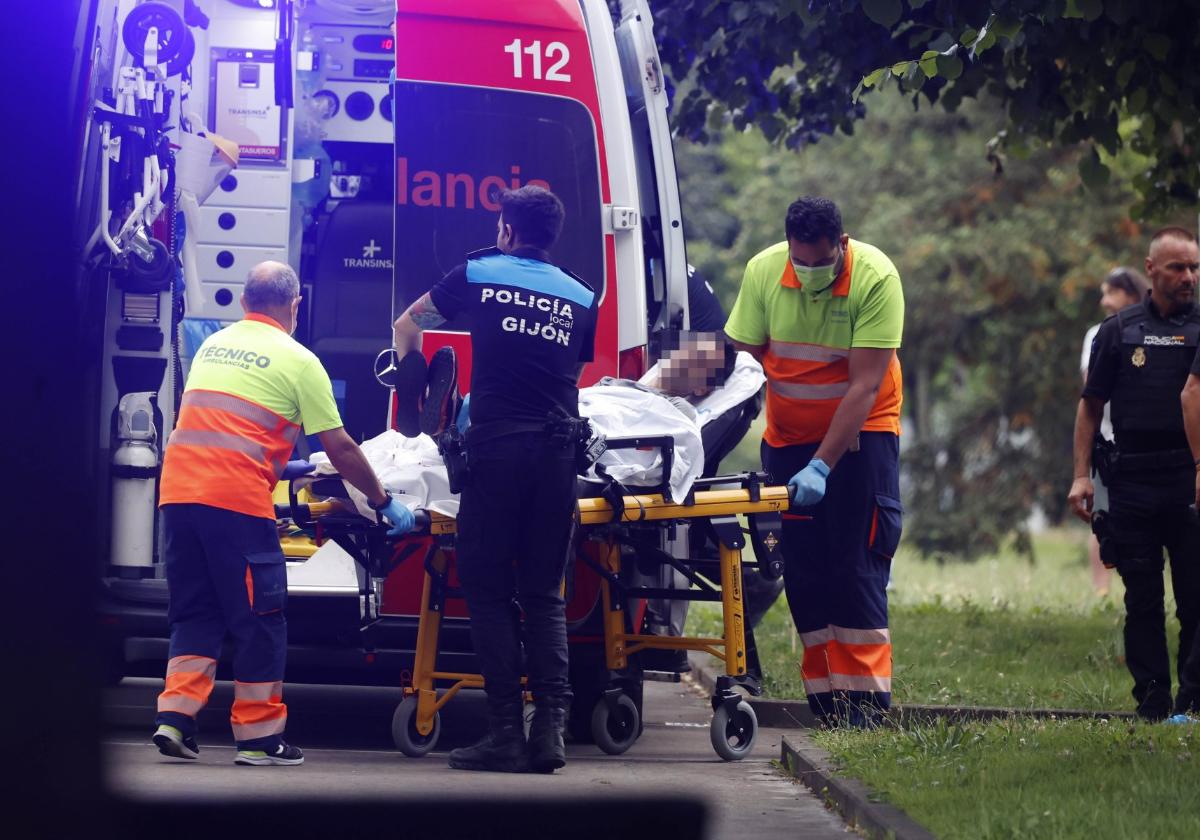 Sanitarios y policías introducen al herido en la ambulancia.