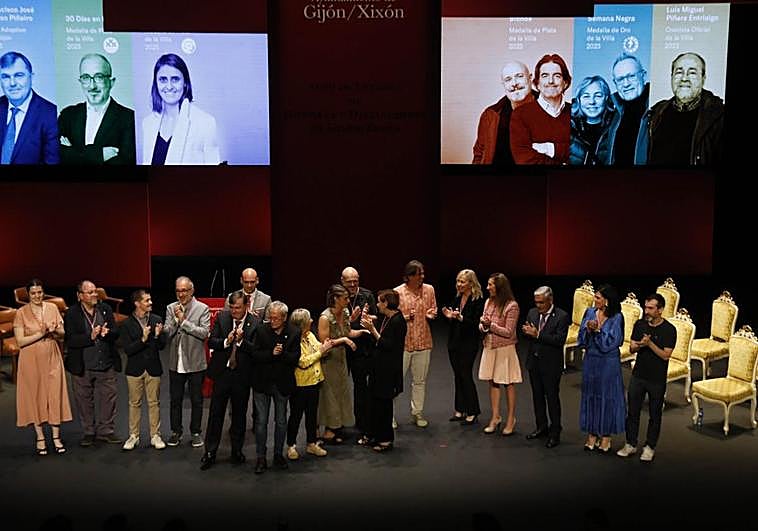 Olaya Suárez, Luis Miguel Piñera, Javier Suárez Llana, Carlos Rodríguez, Francisco José Vizoso, Jesús Martínez Salvador, Ángel de la Calle, Susana Quirós, Manuela Fernández, Carmen Moriyón, Tito Valdés, Sara Álvarez Rouco, Ángela Pumariega, Luis Manuel Flórez, Inmaculada Fernández y Fran Fernández, en el escenario del Teatro Jovellanos tras la entrega de las medallas.