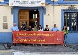 Las autoridades sostienen el cartel de la campaña.