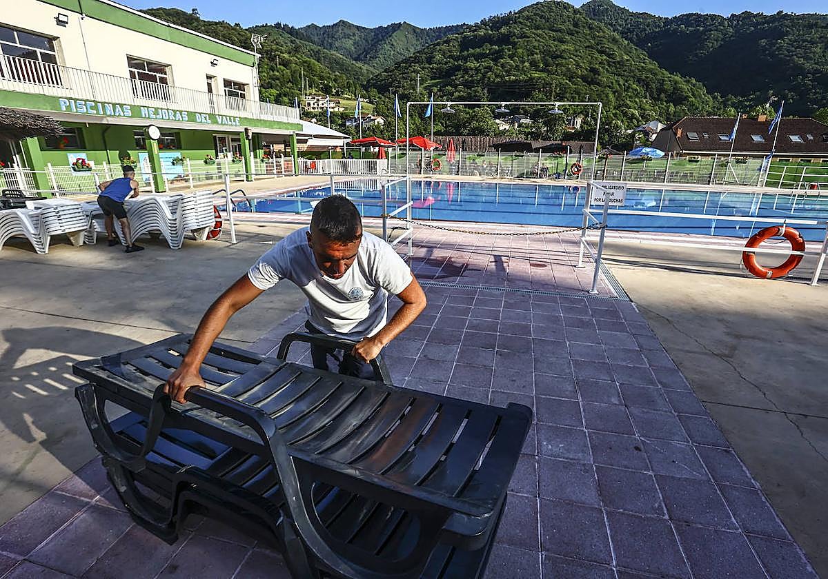 Pablo Zapico, quien salvó a la mujer, recoge las hamacas antes de cerrar la piscina.