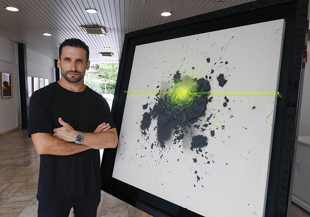 Carlos García junto al lienzo del cartel.