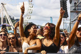 Dos jóvenes alzan las manos en uno de los conciertos de la tarde de este viernes