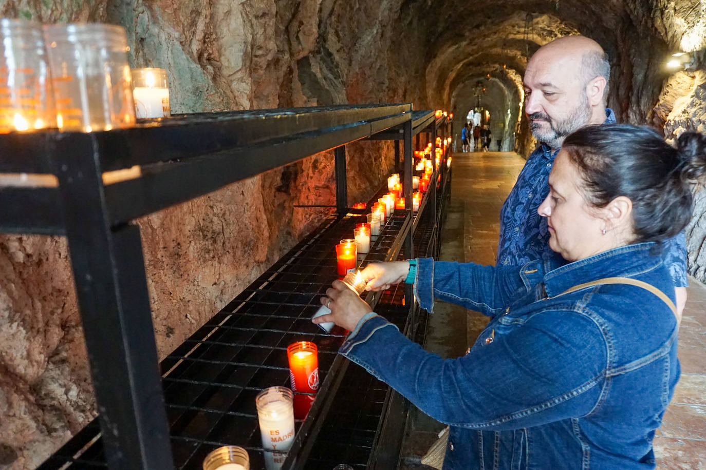 Imagen principal -  Celia Acebedo y Alfredo Mosquera, de Toledo, pusieron una vela a la Santina. | María del Castellar bebe de la fuente de los Siete Caños. | Fermín González y Carmen Moreno, de Sevilla, bajo la Santa Cueva. 