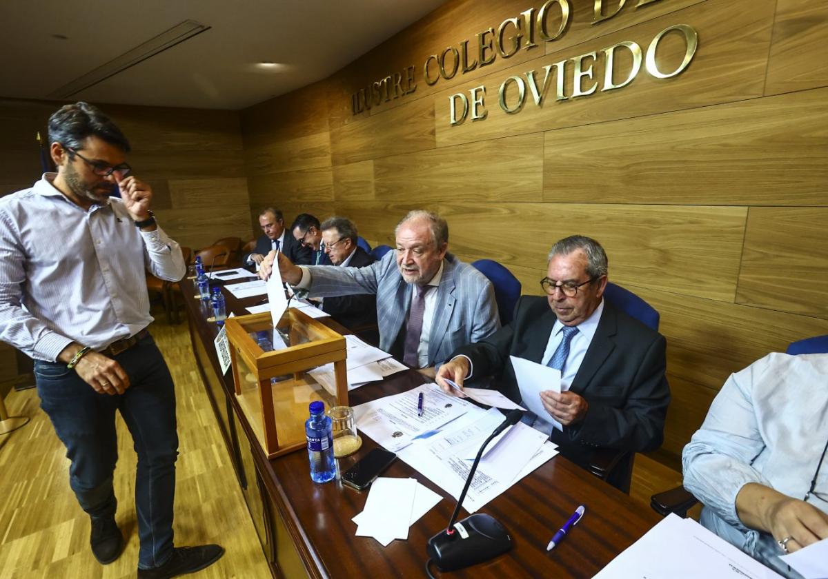 El presidente de la Real Academia Asturiana de la Jurisprudencia, Leopoldo Tolivar, introduce uno de los votos en la urna.