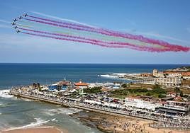 Formación del final de la exhibición de la Patrulla Águila formando con humo los colores de la bandera de España, en la zona derecha de la bahía.