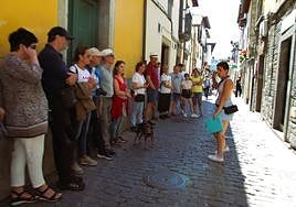 La guía turística Luz María Díaz recorre las calles de Cangas con un grupo de veinte turistas.