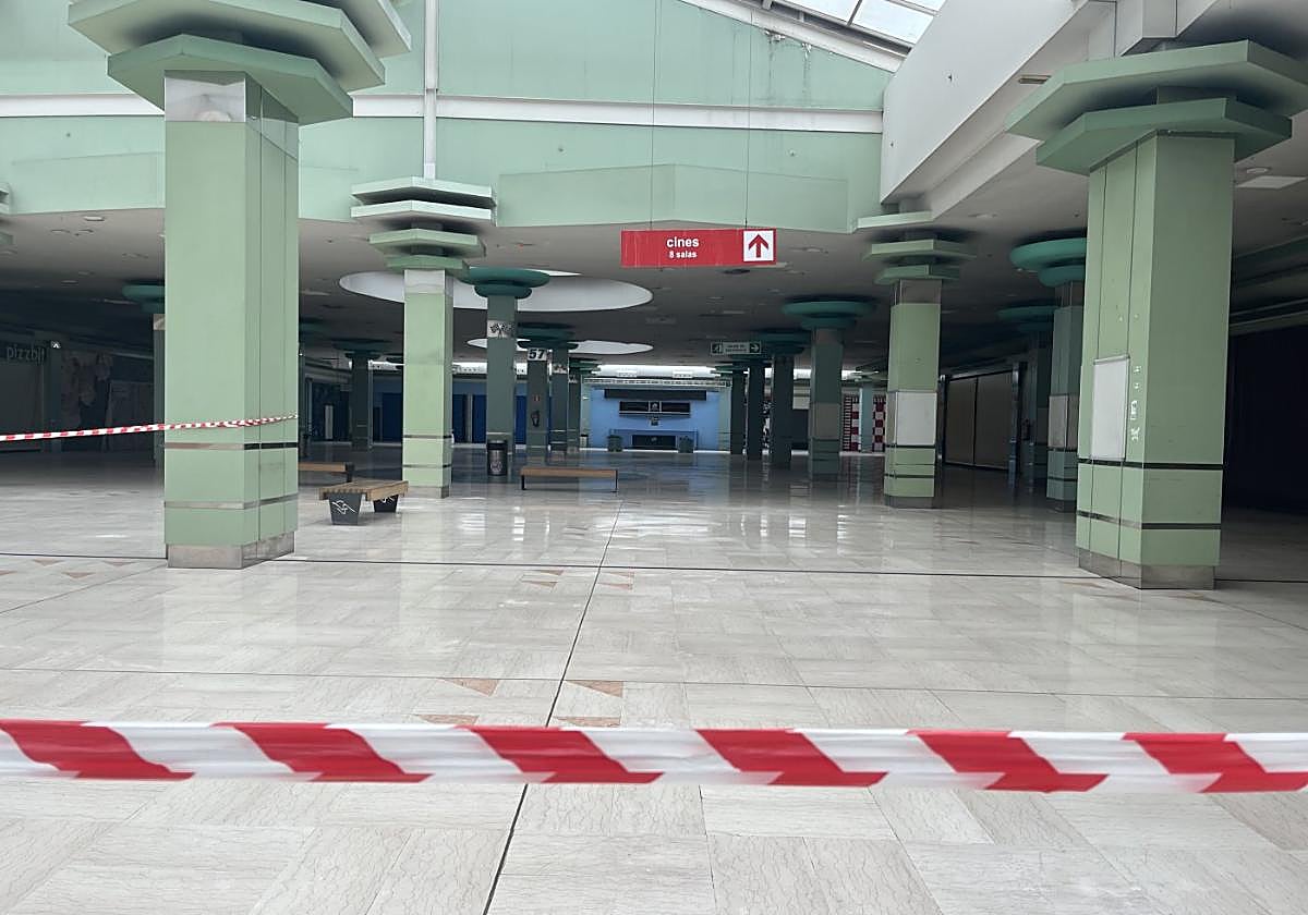 Galería de tiendas y restauración del centro comercial del Nalón, sin actividad y precintada.