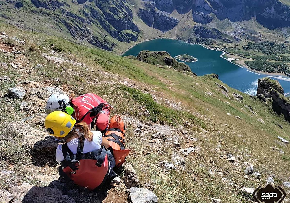 Un efectivo del equipo de rescate auxilia a la senderista herida en Somiedo.