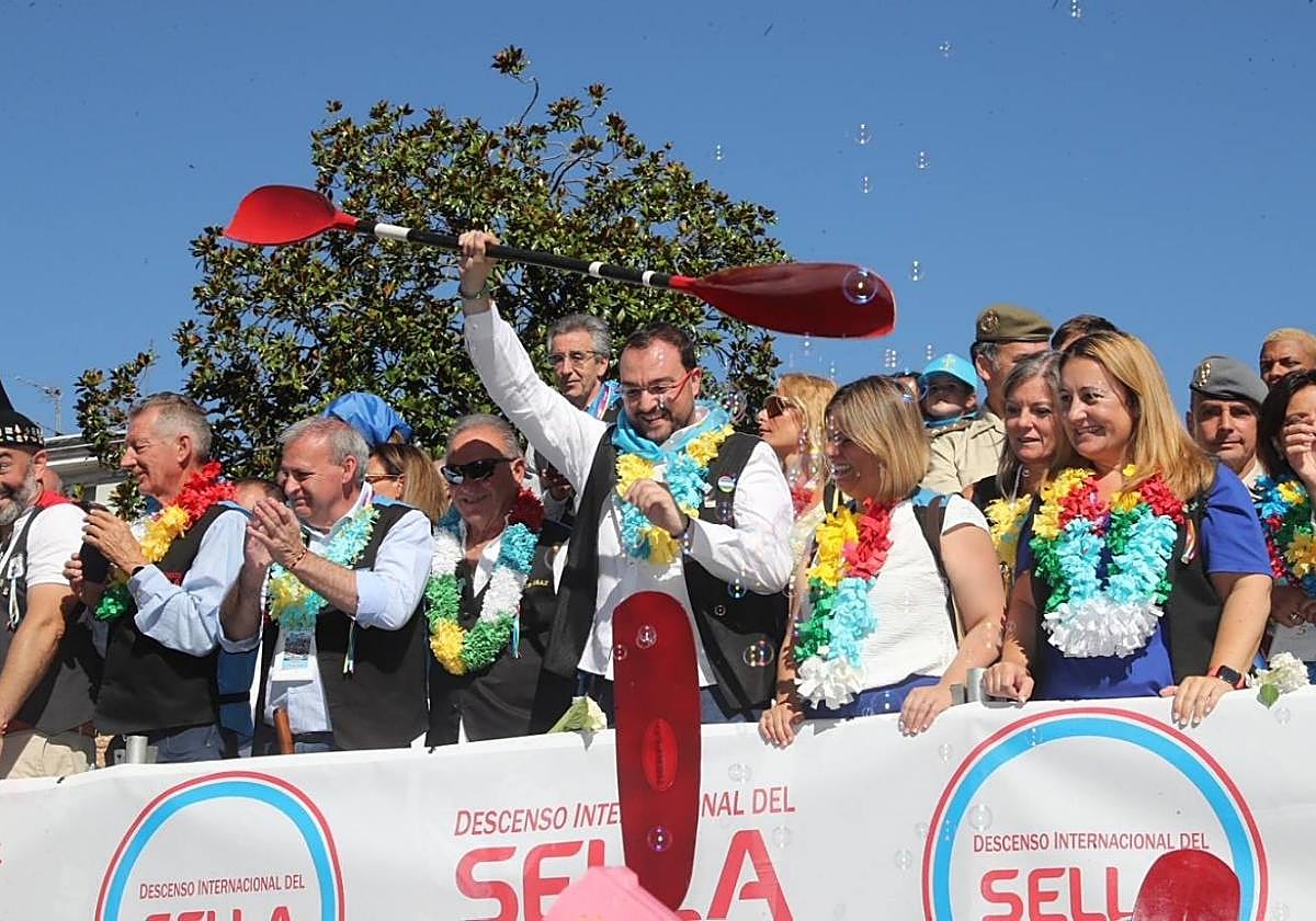 Adrián Barbón, pala en mano, durante el desfile de Arriondas, acompañado de la vicepresidenta Gimena Llamedo y el resto de autoridades presentes en el Sella.