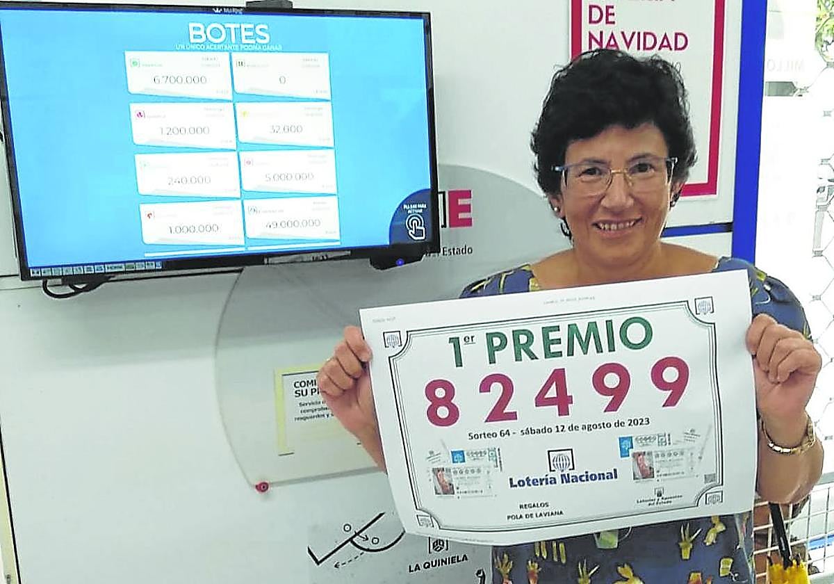 La responsable del despacho de lotería, Ana Isabel González, muestra el número agraciado.