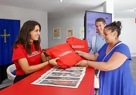 Irene Cervantes entrega la bolsa de EL COMERCIO a Yamena López y Luis Enrique Fernández, asiduos a este periódico: «Todas las mañanas leemos el digital». Gracias a la bolsa de la Feria tienen un mes de suscripción gratuita, una cantimplora con el logo del periódico y numerosos regalos.