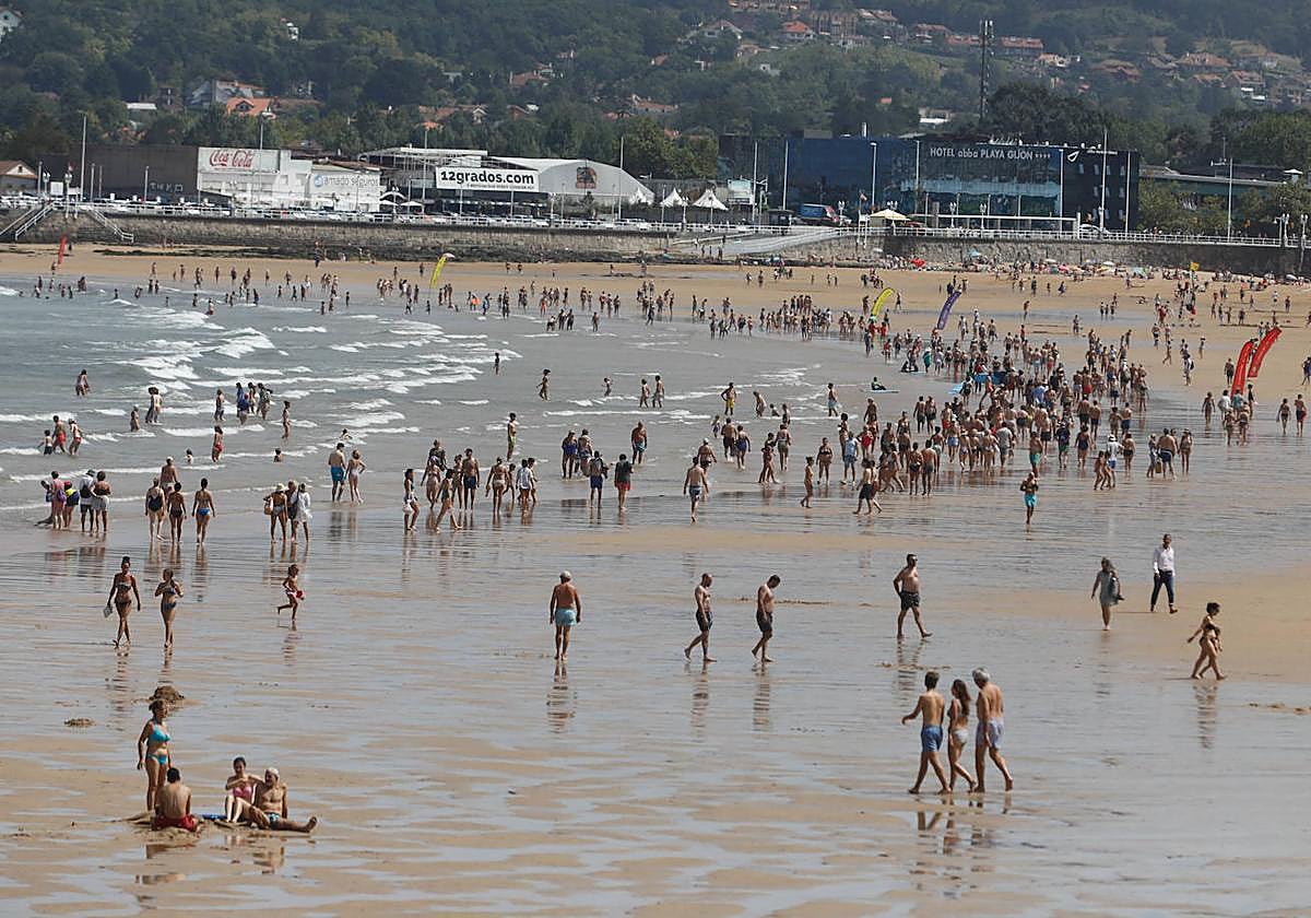 La playa de San Lorenzo, este martes, sirvió de refugio a miles de personas contra el calor.