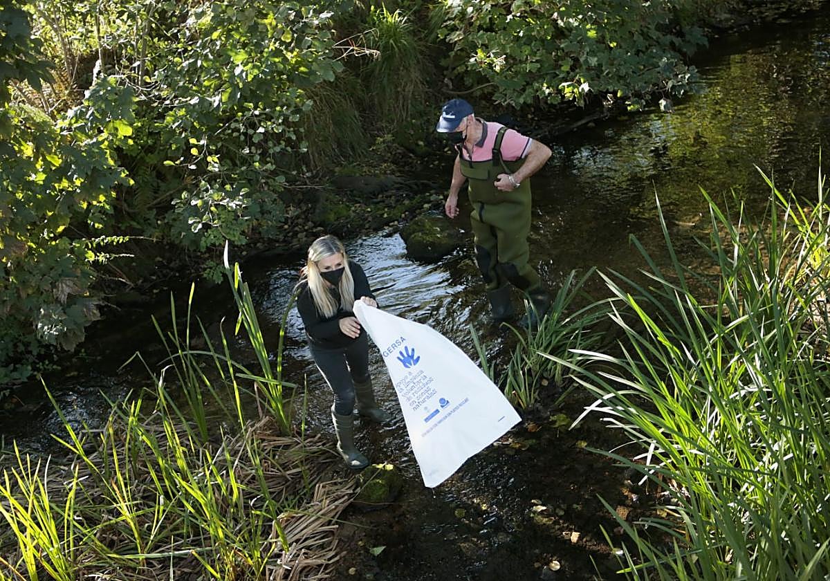 Los vecinos limpian el río en una edición pasada de la actividad.