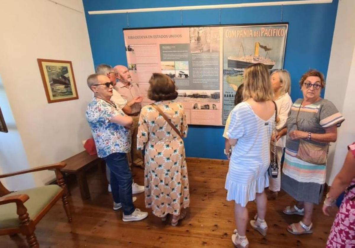 Varios asistentes observan la exposición en la Casa de Piedra.