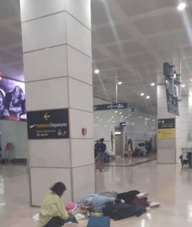 Imagen secundaria 2 - Pasajeros en el aeropuerto pasando la noche y pantalla en la que se anunciaba el mismo. 