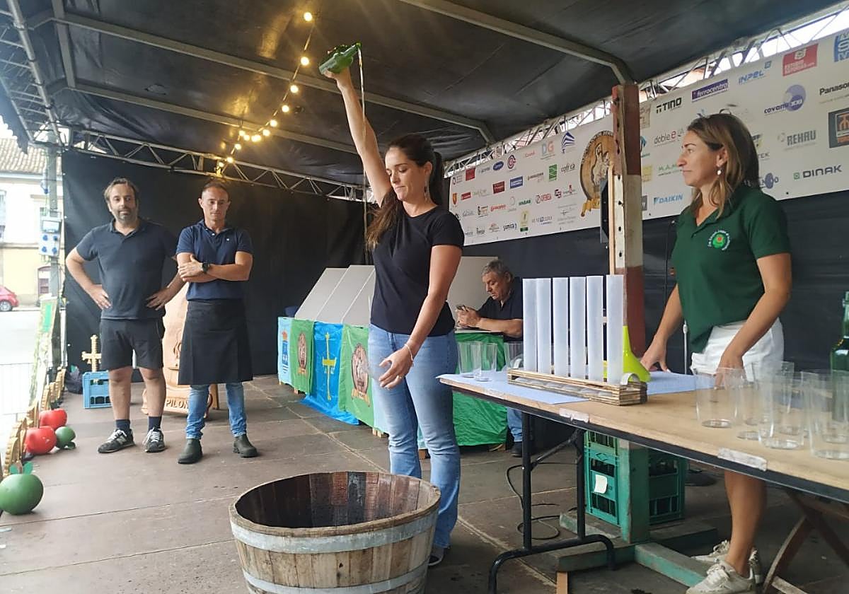 Aída Groeiro, de Tineo, escancia ante Luis Sariego, presidente de la Asociación de la Sidra Casera; Marcos Ramos, escanciador y jurado, y Laura Ovin, escanciadora y jurado.