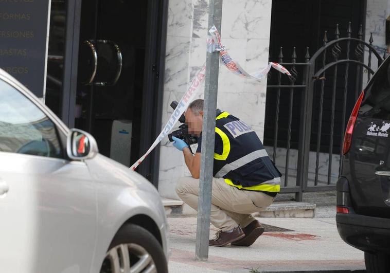 Una agente de la Brigada de la Policía Científica toma fotografías de la escena del crimen.