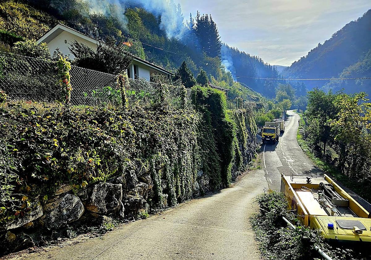 Imagen principal - Vecinos y efectivos en la zona se esfuerzan por controlar el avance de las llamas.