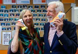Martin Cooper y su mujer, Arlene Harris, posan con dos réplicas decoradas de los primitivos teléfonos móviles.