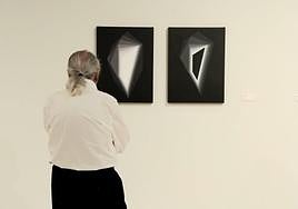 Dos piezas oscuras y un hombre contemplándolas.