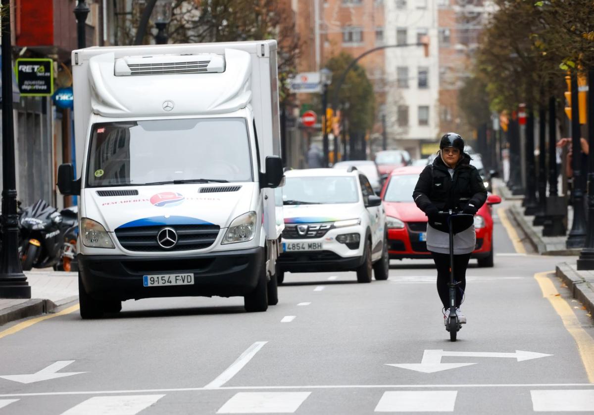 Una mujer circula en patinete eléctrico entre el tráfico por la avenida de la Costa.