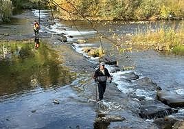 Pescadores recogiendo basura en el caudal.