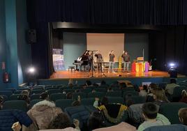 Los niños agitan sus instrumentos en el aire durante el concierto con juguetes.