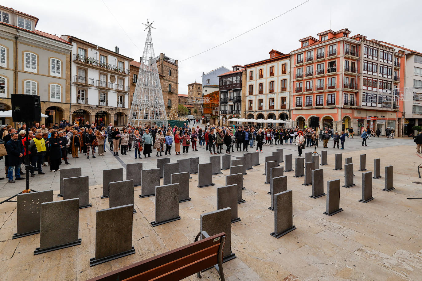 La Corporación municipal de Avilés posa en la plaza de España ante 53 lápidas con los nombres de otras tantas mujeres asesinadas este año por sus parejas o exparejas