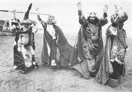 Aliatar, Melchor, Gaspar y Baltasar saludan a los gijoneses tras aterrizar en helicóptero sobre la arena de la playa de San Lorenzo.