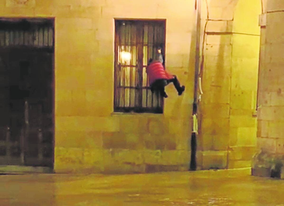 Un joven trepa la fachada del ayuntamiento de Oviedo.