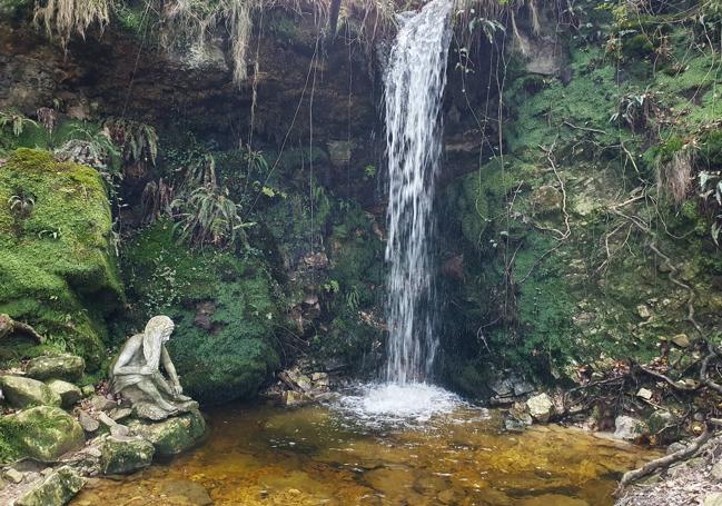 Salto de agua y figura de Xana en piedra en el arroyo del Toyu