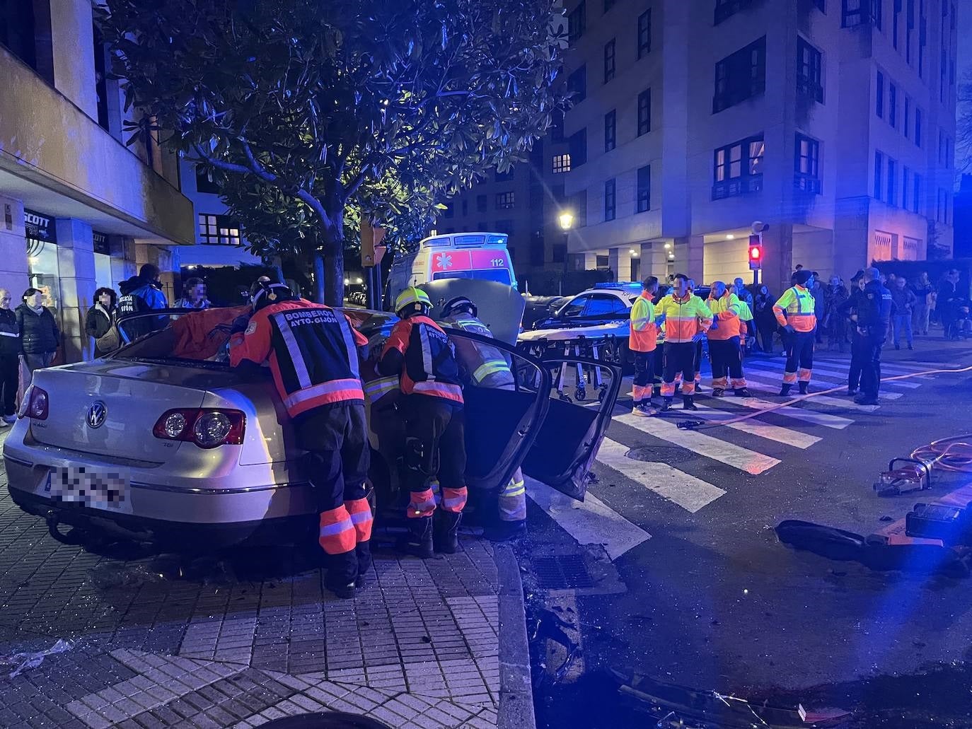 Espectacular choque entre un coche de la Policía y un turismo en Gijón